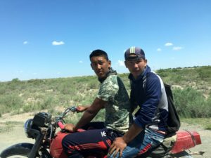 Two young guys on a motorbike stopped to say hello